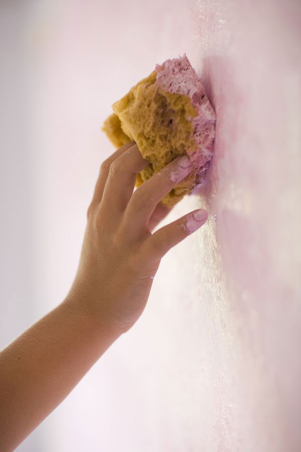 a hand texture-a-wall-with-a-sponge